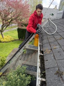 homeowner vacuuming the guter with vacuum hose