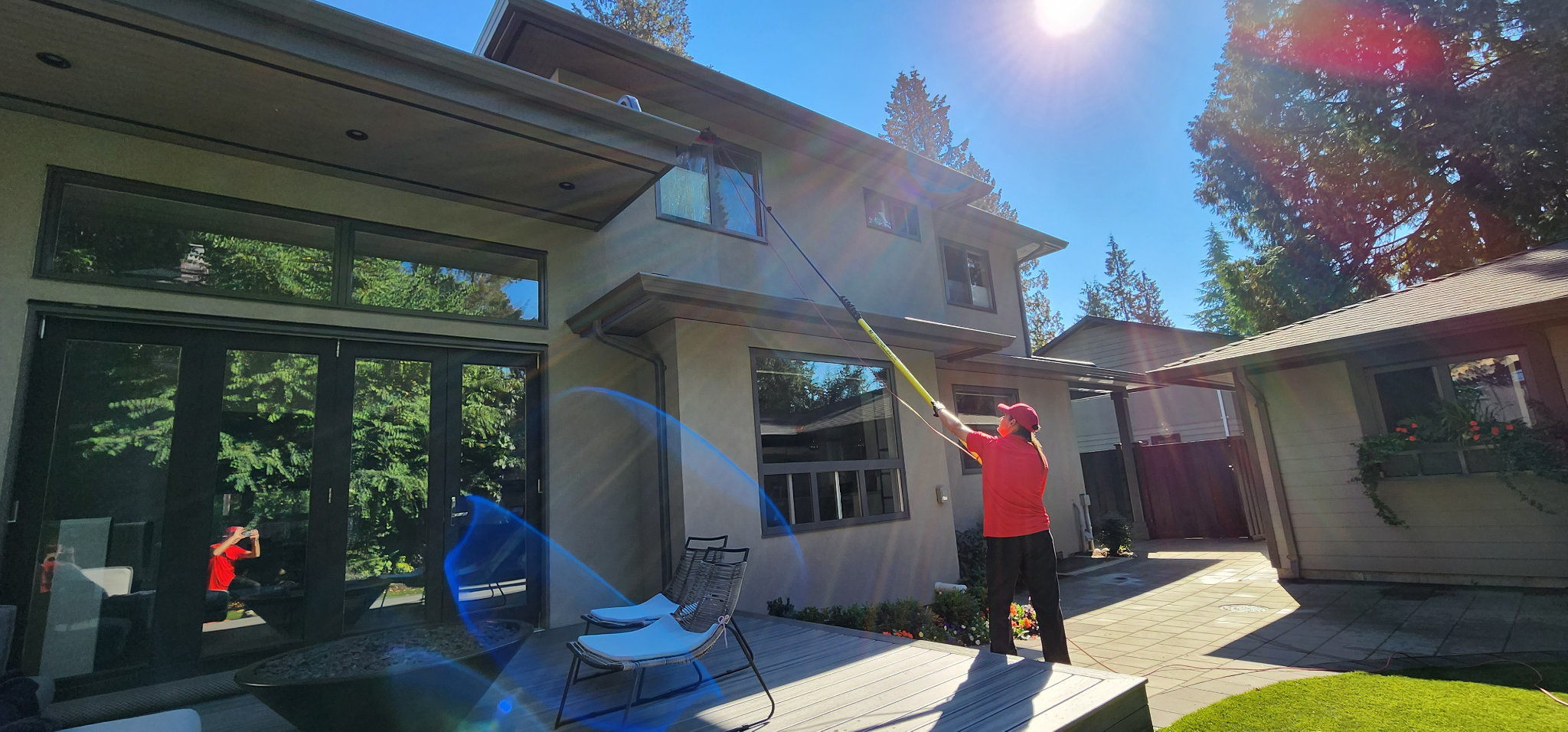 Guttervac team member cleaning upper level house window